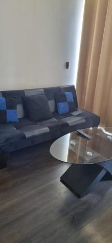 a living room with a couch and a glass table at Condominio en La Florida in Santiago