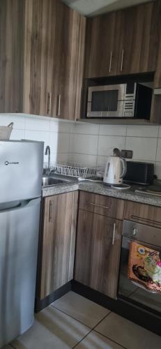 a kitchen with a white refrigerator and a microwave at Condominio en La Florida in Santiago