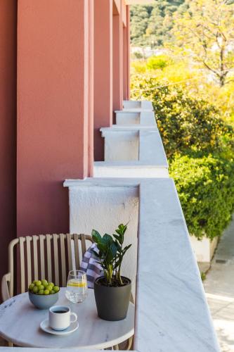 a table with a coffee cup and a plant on a balcony at Casa Blue Hotel, Philian Hotels and Resorts in Skiathos Town
