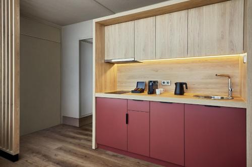 a kitchen with red cabinets and a sink at Sheraton Frankfurt Airport Hotel & Conference Center in Frankfurt/Main