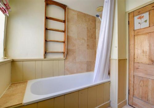 a bath tub in a bathroom with a shower at Half Moon Inn in Aylsham