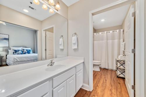 ein weißes Badezimmer mit einem Waschbecken und einem Spiegel in der Unterkunft Palacio Unit 101 in Pensacola