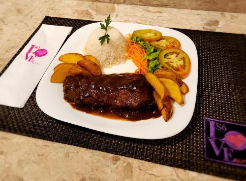 a plate of food with meat and rice and vegetables at Motel Só Love 3 in Sao Paulo