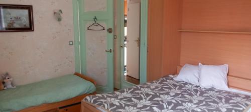 une chambre avec un lit et une porte donnant sur une pièce dans l'établissement Résidence M., à La Bourboule