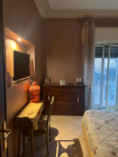 a bedroom with a bed and a table and a television at Specter Guesthouse in Nettuno