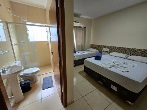 a bathroom with two beds and a toilet and a shower at Pousada Santa Gianna in Aparecida
