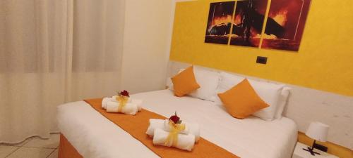 a bedroom with a bed with white sheets and orange pillows at G&G Giusy e Gabry in Santhià