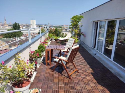 - un balcon avec des chaises et une table dans un bâtiment dans l'établissement Penthouse apartment, à Novi Sad