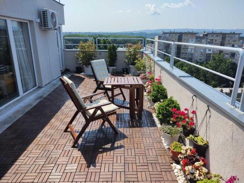 d'une terrasse avec 2 chaises et une table sur un balcon. dans l'établissement Penthouse apartment, à Novi Sad