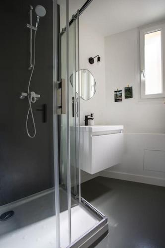 une salle de bain avec une douche en verre et un lavabo dans l'établissement Appartement 3 pièces / proche plage / centre / clim, à Antibes