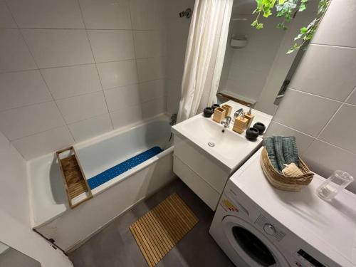 La salle de bains est pourvue d'un lavabo et d'un lave-linge. dans l'établissement Grand appartement lumineux avec terrasse, à Courcouronnes