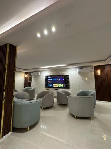a waiting room with chairs and a flat screen tv at Dorat alsafaa in Hafr Al Baten