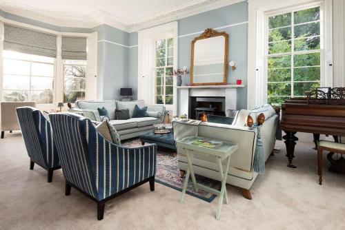 a living room with a couch and a piano at Cairnbank House & Garden Apartment in Duns