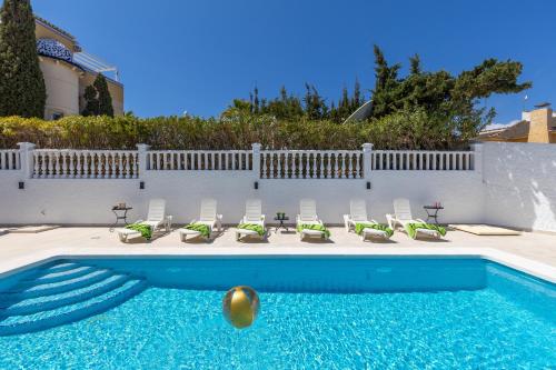 einen Pool mit Stühlen und einem Ball im Wasser in der Unterkunft Fidalsa Grand Mediterranean Beachfront in Playa Flamenca