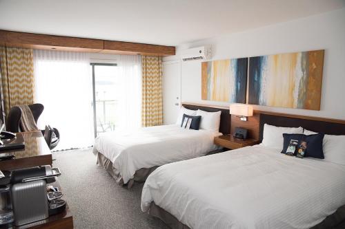 a hotel room with two beds and a large window at Qualicum Beach Inn in Qualicum Beach