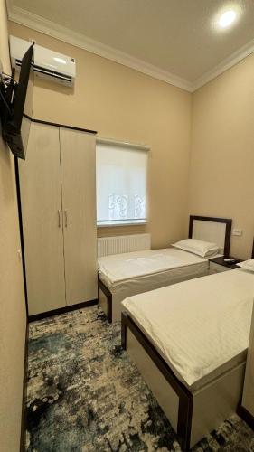 a hotel room with two beds and a window at Islomobod in Tashkent