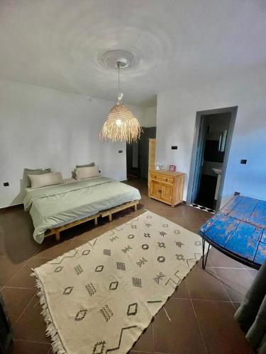 a bedroom with a bed and a table and a rug at Chill House surf camp in Sidi Kaouki