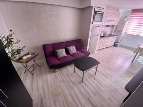 sala de estar con sofá púrpura y mesa en Like Home en Arad