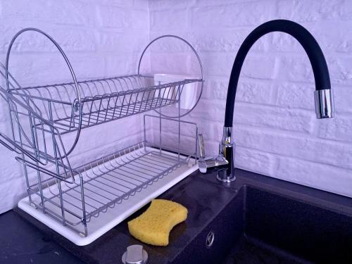 a sink with a wire basket and a sponge at Like Home in Arad