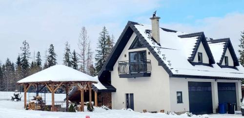 ein schneebedecktes Haus mit einem Pavillon in der Unterkunft Dreamplace in Ząb