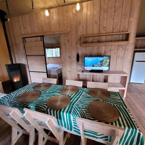 Zimmer mit einem Tisch und Stühlen sowie einem TV in der Unterkunft Heated & brand new Forestlodge in Renesse
