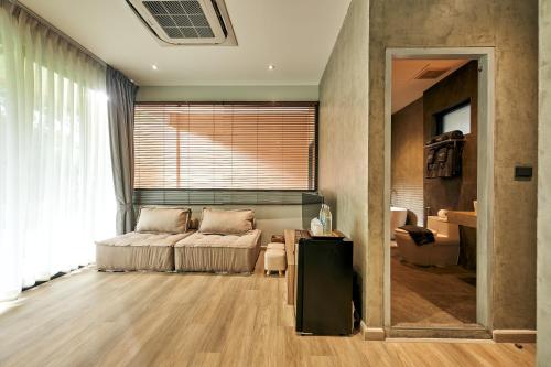 a living room with a couch and a table at Baan Rai Santisuk in Ban Sok Dua