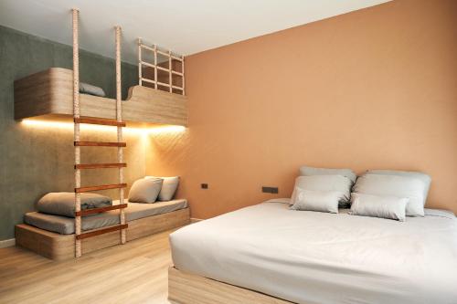 a bedroom with a bed and a loft bed with a ladder at Baan Rai Santisuk in Ban Sok Dua