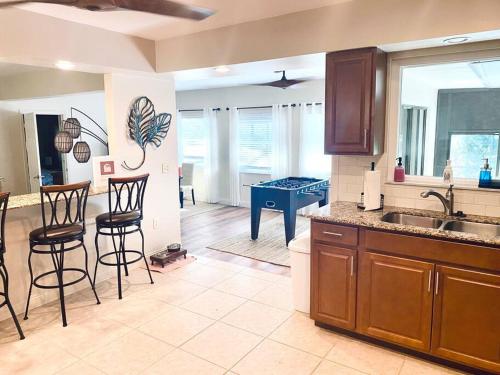 a kitchen with bar stools and a kitchen with a table at Heated Saltwater Pool Home Minutes to Beach in Englewood