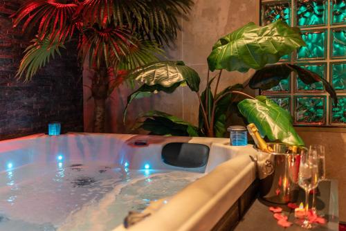 une baignoire jacuzzi dans une pièce ornée de plantes dans l'établissement L’Insolite, Spa Privatif (Appartement Jacuzzi), à Toulouse