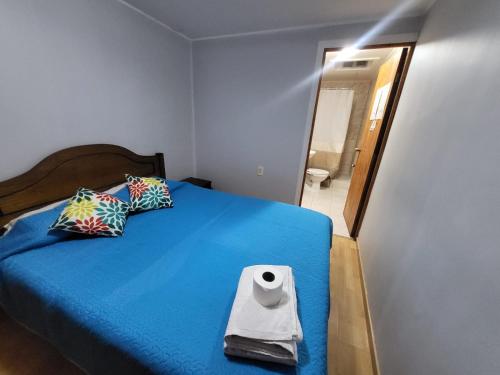 ein Schlafzimmer mit einem blauen Bett und Toilettenpapier in der Unterkunft Hostal aleja in Caldera