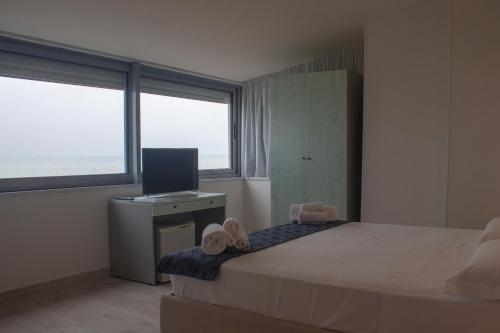 a bedroom with a bed and a desk with a television at Da Mariolino in Numana