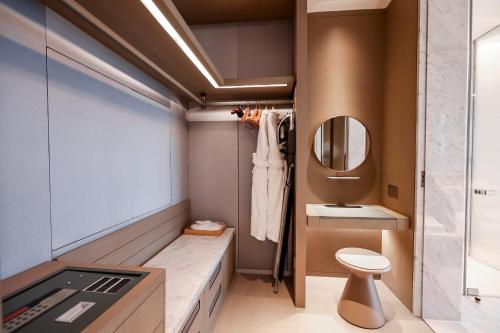 a bathroom with a sink and a toilet and a mirror at Vignette Collection The Xanadu Guangzhou, an IHG Hotel in Guangzhou