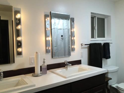 een badkamer met een wastafel, een toilet en een spiegel bij Hobby Farm in the City in Spokane Valley
