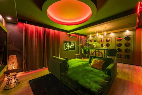 ein Wohnzimmer mit grüner Couch und roten Vorhängen in der Unterkunft L’Insolite, Spa Privatif (Appartement Jacuzzi) in Toulouse