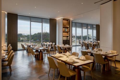 a restaurant with tables and chairs and large windows at Vignette Collection The Xanadu Guangzhou, an IHG Hotel - -Free Canton Fair Shuttle Bus and Registration Counter in Guangzhou