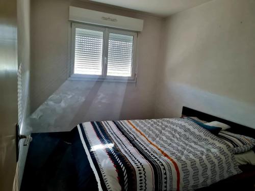 une chambre avec un lit et une fenêtre dans l'établissement Logement entier appartement pas loin du circuit des 24, au Mans