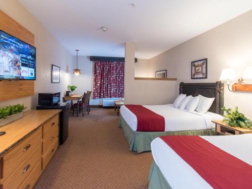 クイーンズベリーにあるSix Flags Great Escape Lodge & Indoor Waterparkのベッド2台、薄型テレビが備わるホテルルームです。