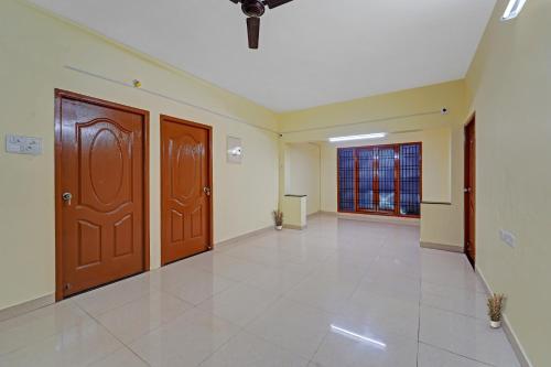 um corredor com duas portas de madeira e um piso de azulejo em Flagship Maxworth em Chennai