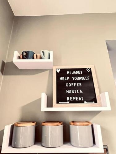 a shelf with cups and a sign in a room at Lakeland Living - Devenish Manor in Enniskillen
