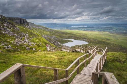 a wooden boardwalk on a hill with a lake at Lakeland Living - Devenish Manor in Enniskillen