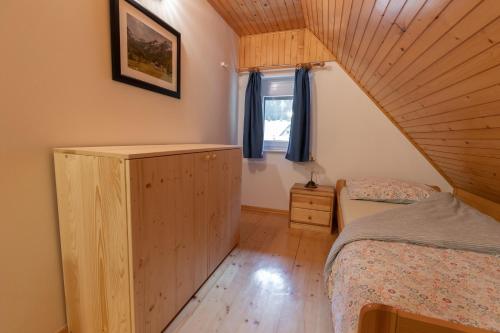 a small bedroom with a bed and a window at Metoja in Soča