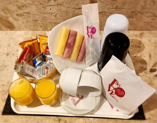 a plate with some food and drinks on a table at Motel Só Love 4 in Sao Paulo