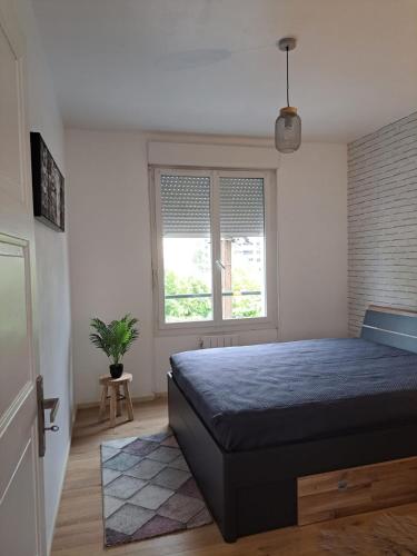 een slaapkamer met een bed en een raam bij Confortable Apart de 3 pièces in Poitiers