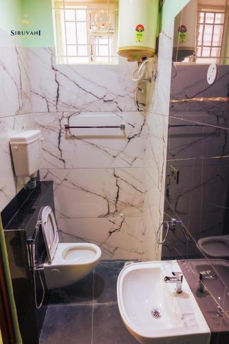a bathroom with a toilet and a sink at Siruvani Residency - Near Isha Foundation Coimbatore in Alāndurai