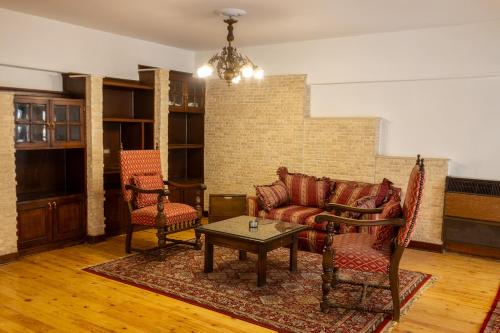a living room with a couch and two chairs and a table at Grand Egyptian Museum Pyramids Apartment in Cairo