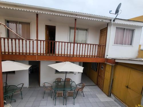 a balcony of a building with a table and chairs at Hostal aleja in Caldera