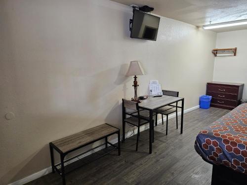 a room with a bed and a table with a lamp at California Suites Motel in Calexico