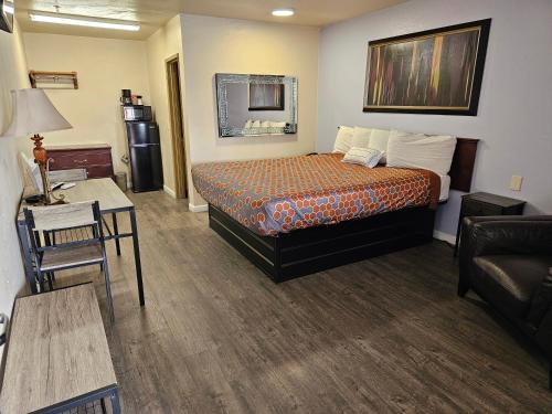 a small hotel room with a bed and a couch at California Suites Motel in Calexico