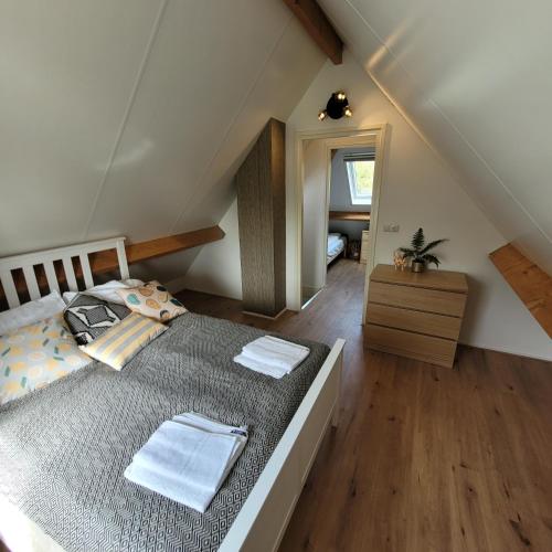 um quarto com uma cama num sótão em Ecolodges De Dreef Guesthouse em Renesse