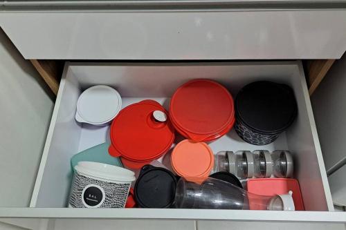 a drawer filled with different colored plates and cups at Apto inteiro - WiFi, ar condicionado, Piscina in Cuiabá